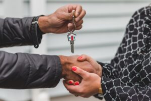 two-people-shaking-hands-and-handing-over-house-keys